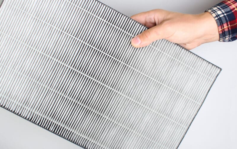 Pensacola homeowner holding an air filter for heater