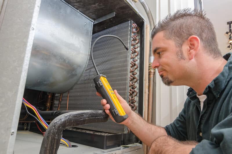 AC technician inspecting cooling system